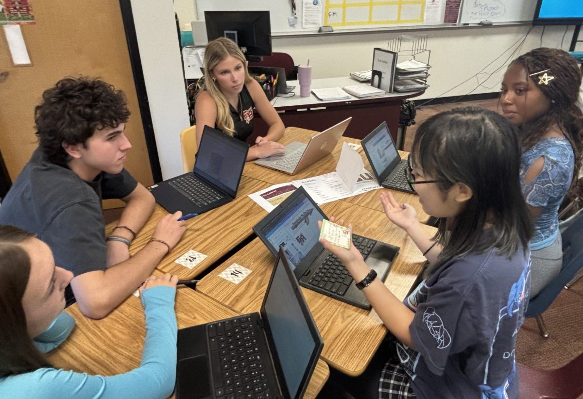Section Editors Madison Platt and Cooper Burch, Assitant Editor Skylar Fleming, Section Editor Zaniya Brown and Editor-in-Chief Vy Nguyen (from left to right) sit in a editors' meeting to discuss the new branding policies and image of the high school newspaper. 