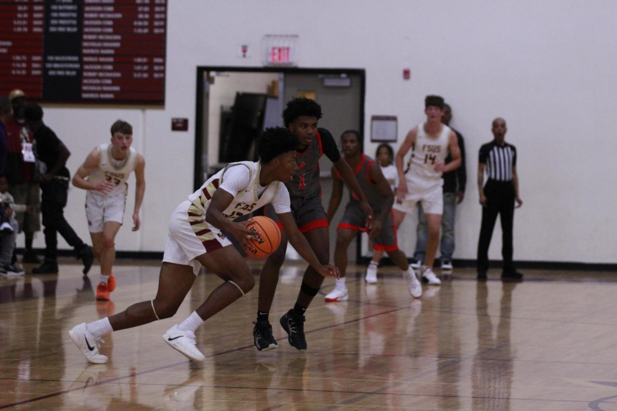Sophomore Ethan Certain dribbles the ball down the court. This season, the basketball team has worked on developing their new identity under a new head coach.
Photo courtesy of The Renegade.