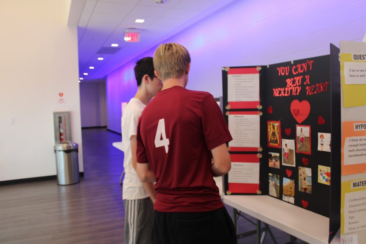 Eighth graders Michael Nall (left) and Matthew Hilliard (right) explore the science fair projects with their class. The Science National Honor Society club members and sponsor Micha Nowak organized the science fair.