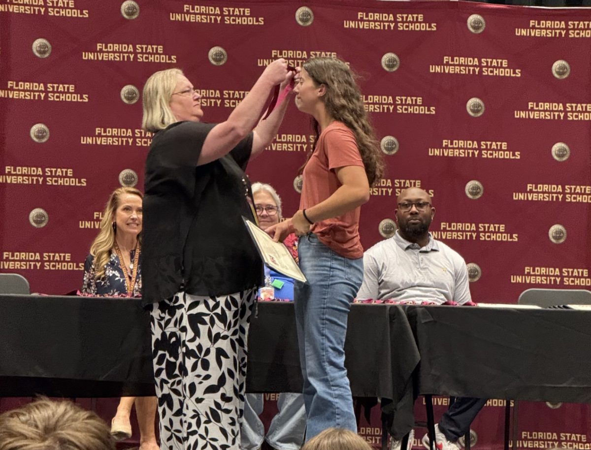 Freshman Kalli Hosmer recieves a medallion award from Principal Megan Brink. Students such as Hosmer were nominated by their teachers for exceptional effort in their classes.
Photo courtesy of Beth Hosmer.